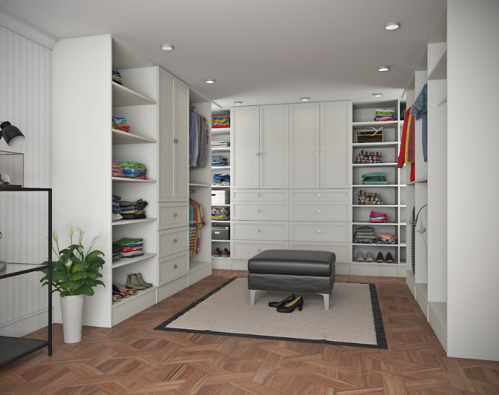 white wooden walk-in closet with black leather ottoman in the center